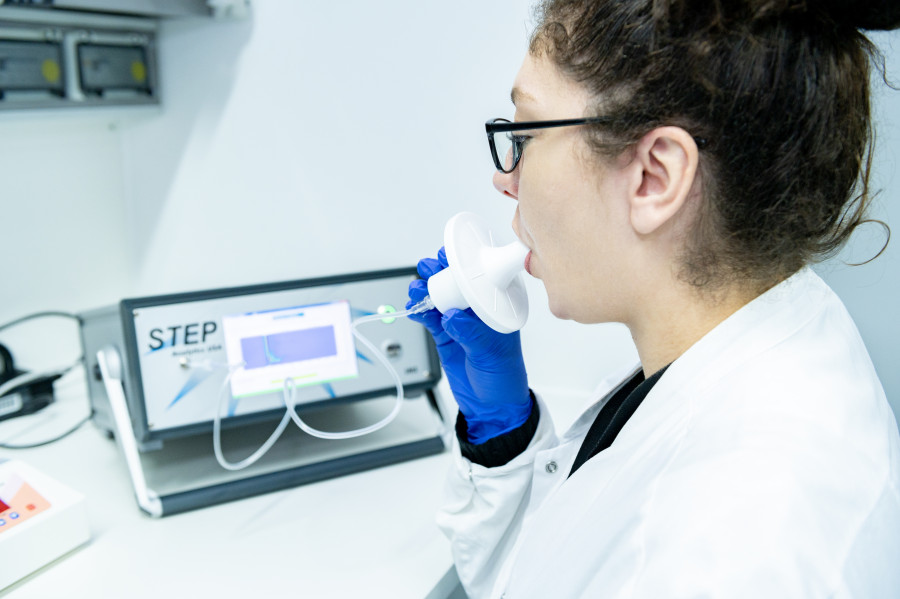 Person atmet in ein Luftmessgerät